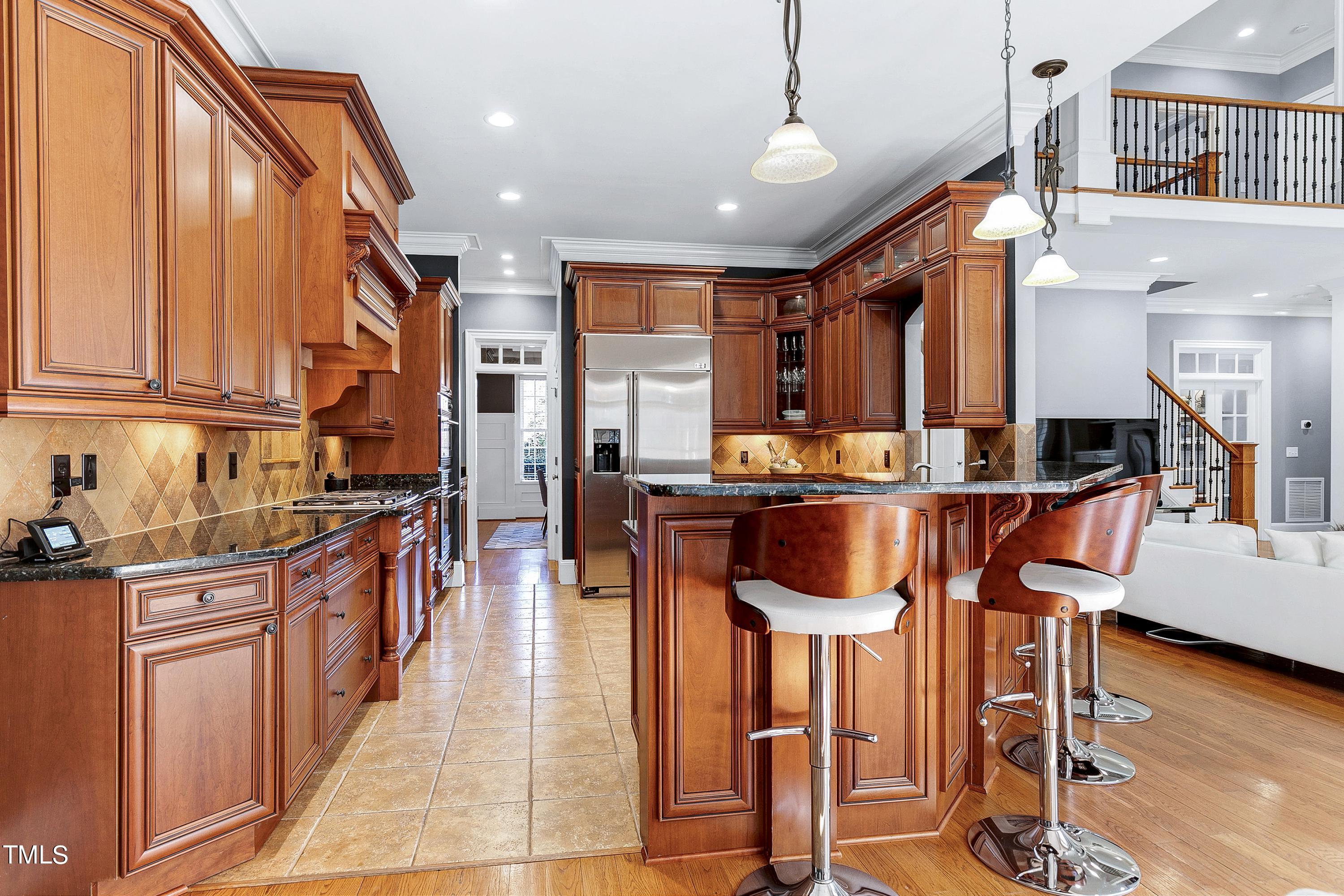 2912 Ryton Court Raleigh, NC 27613 - Photo 22 of 86 a kitchen with stainless steel appliances dining table chairs and wooden floor