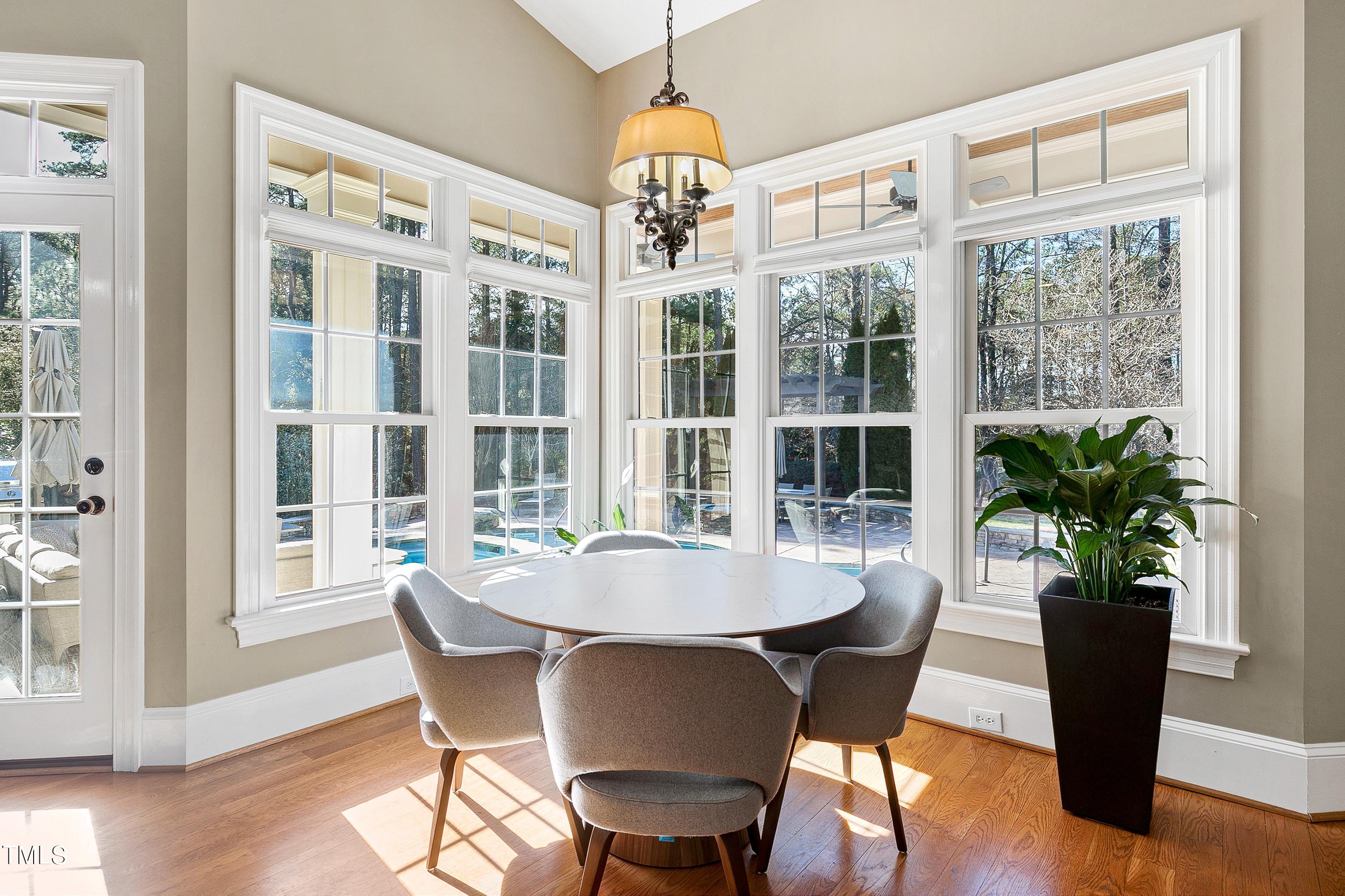 2912 Ryton Court Raleigh, NC 27613 - Photo 26 of 86 a dining room with furniture potted plants and wooden floor