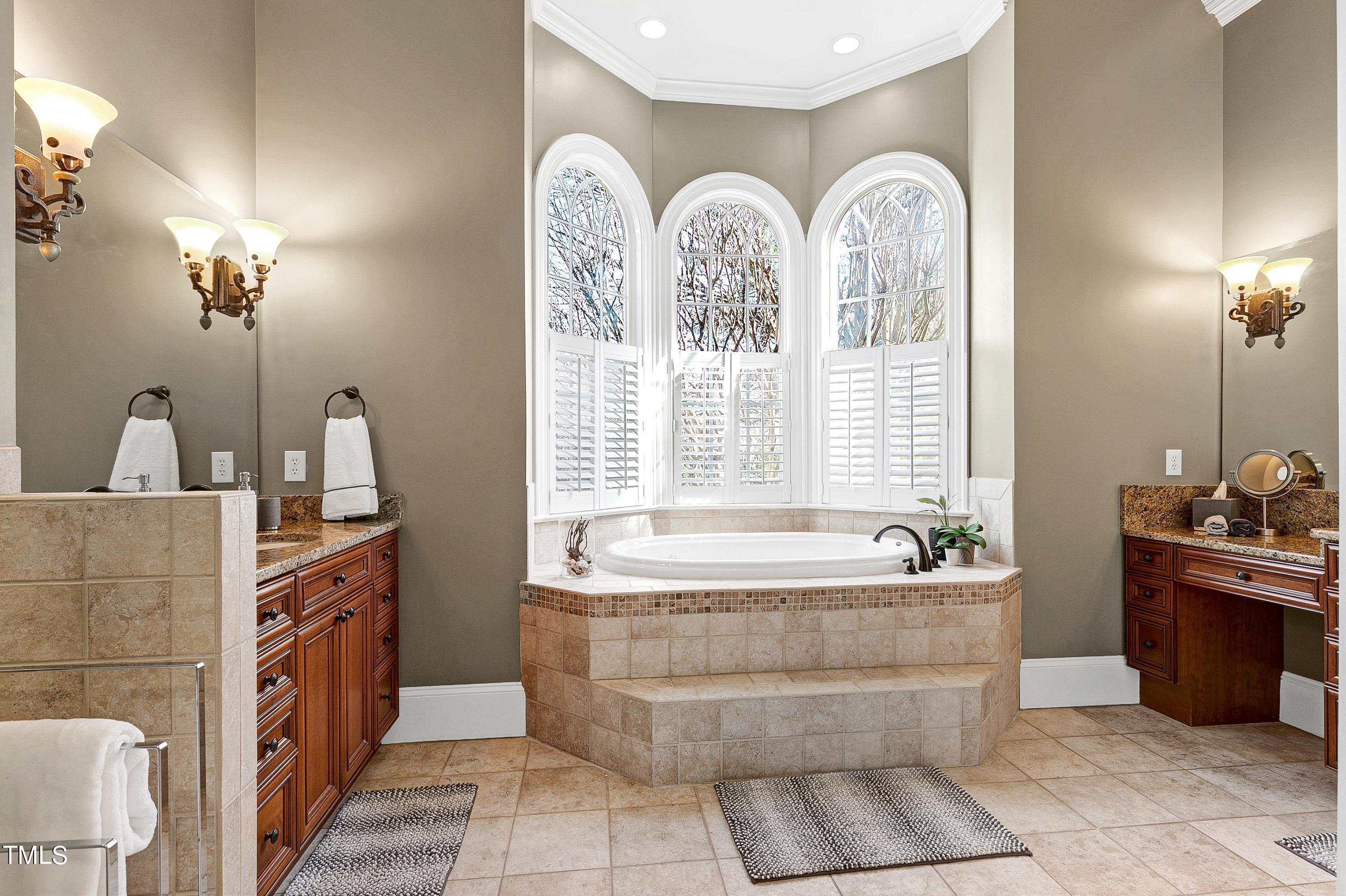 2912 Ryton Court Raleigh, NC 27613 - Photo 30 of 86 a spacious bathroom with a tub a double vanity sink a two mirror a bathtub and next to a window