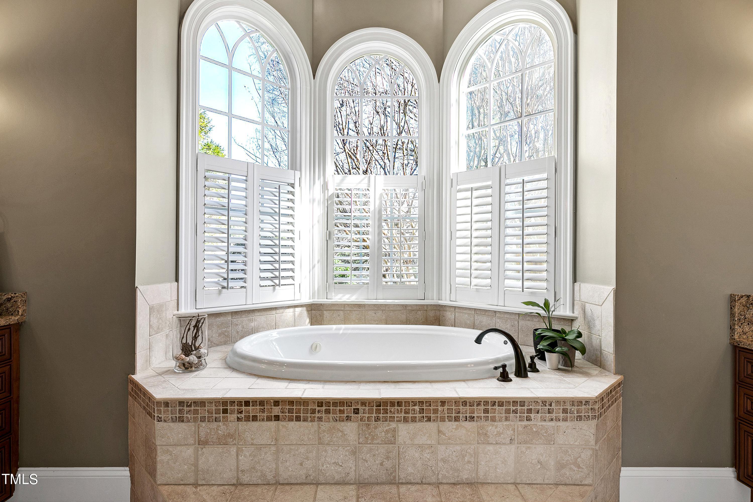 2912 Ryton Court Raleigh, NC 27613 - Photo 31 of 86 a bath tub sitting in a bathroom next to a window