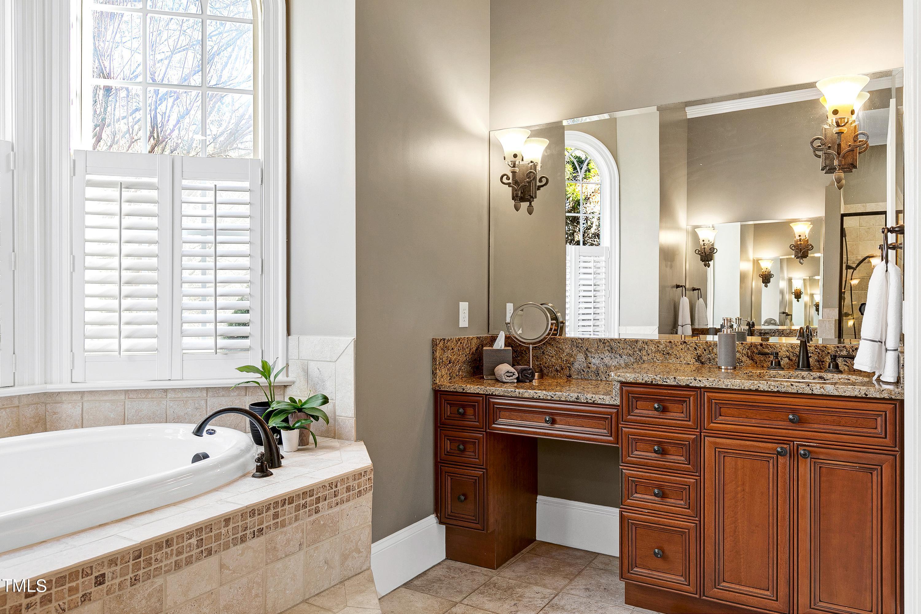 2912 Ryton Court Raleigh, NC 27613 - Photo 33 of 86 a spacious bathroom with a granite countertop sink and a bathtub