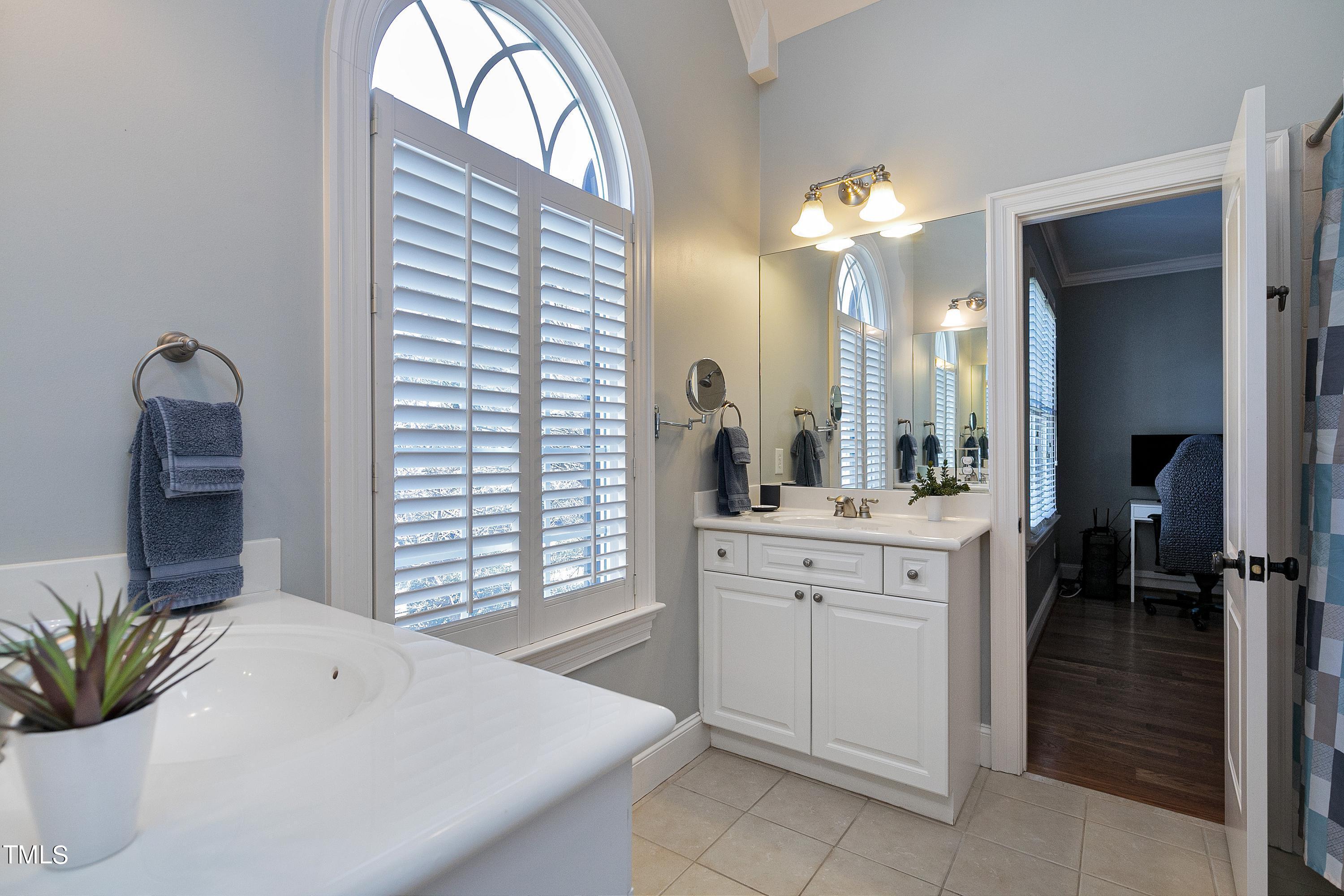 2912 Ryton Court Raleigh, NC 27613 - Photo 51 of 86 a spacious bathroom with a sink and a large mirror