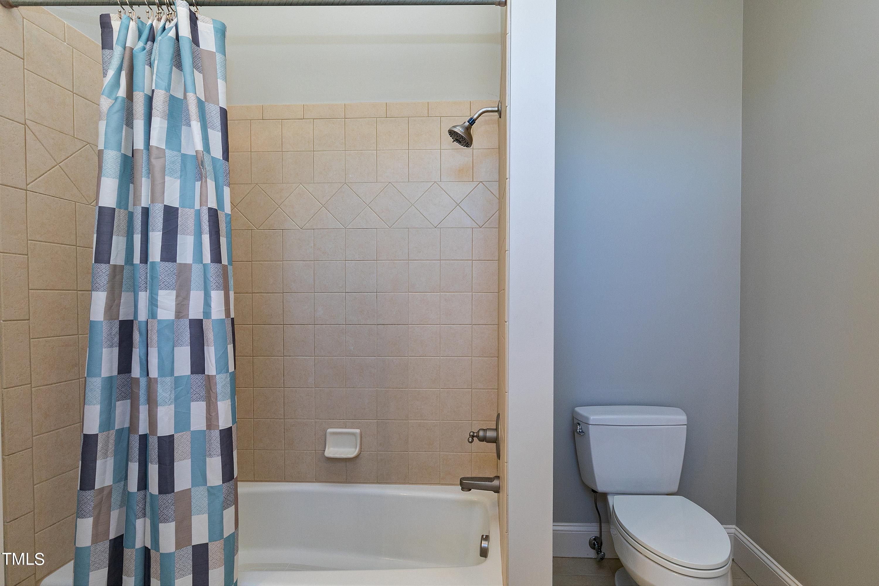 2912 Ryton Court Raleigh, NC 27613 - Photo 52 of 86 a white toilet sitting next to a bathroom sink and tub