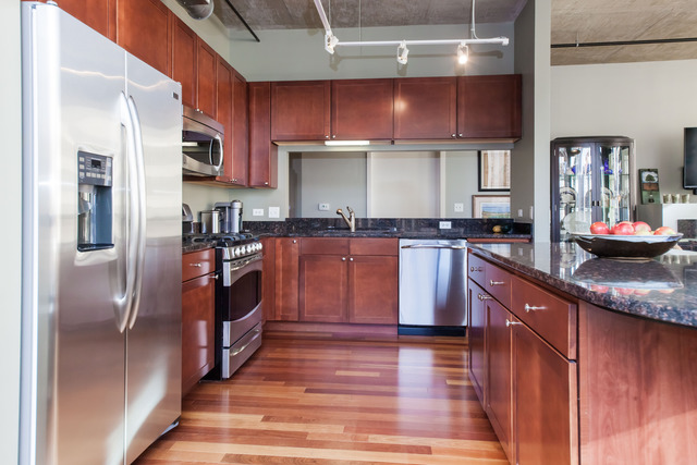 520 South State Street, Unit 501 Chicago, IL 60605 - Photo 12 of 25 a kitchen with stainless steel appliances granite countertop a refrigerator a sink dishwasher a stove with wooden cabinets