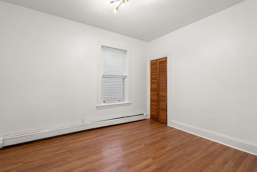 3 Spring Garden Street, Unit 1 Boston, MA 02125 - Photo 10 of 23 an empty room with wooden floor and window