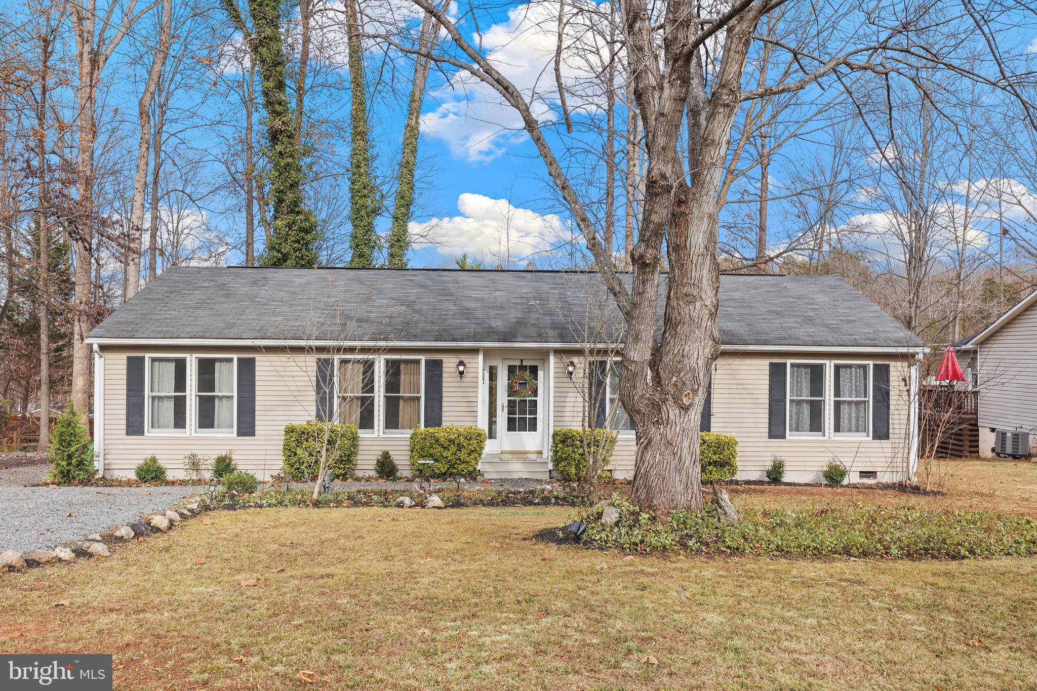 a front view of house with yard and trees around