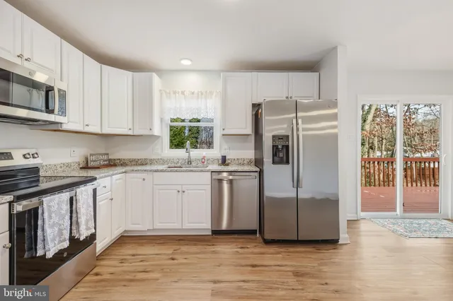 a kitchen with stainless steel appliances granite countertop a refrigerator and a stove top oven