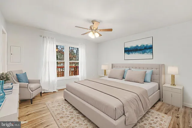 an empty room with wooden floor ceiling fan and windows