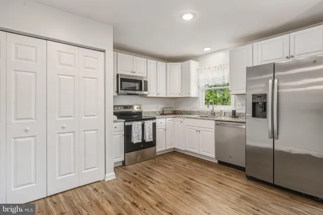 a kitchen with a refrigerator stove and white cabinets