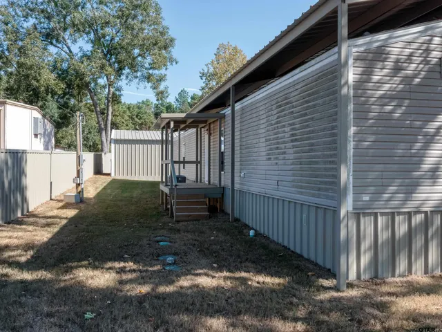 a view of a house with backyard and wooden fence