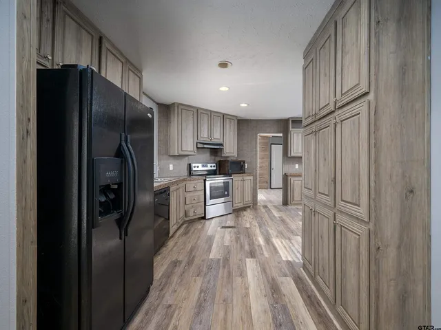 a kitchen with stainless steel appliances granite countertop a refrigerator and a sink
