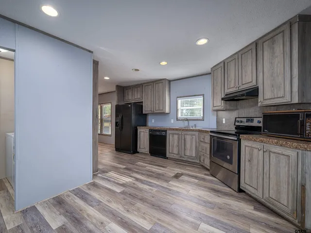 a kitchen with stainless steel appliances granite countertop a refrigerator and a stove top oven