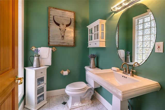 a bathroom with a toilet a sink and mirror
