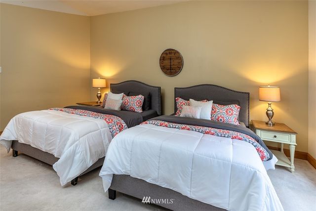 a bedroom with two beds and painting on the wall