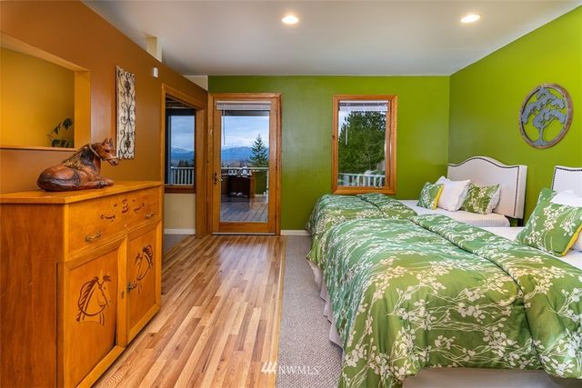 a bed sitting in a spacious bedroom next to a window