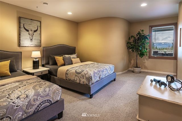 a bedroom with two beds and potted plant on dresser