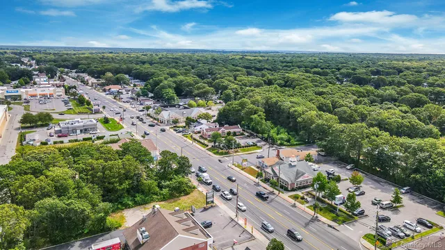 an aerial view of a city with lots of residential buildings ocean and mountain view in back