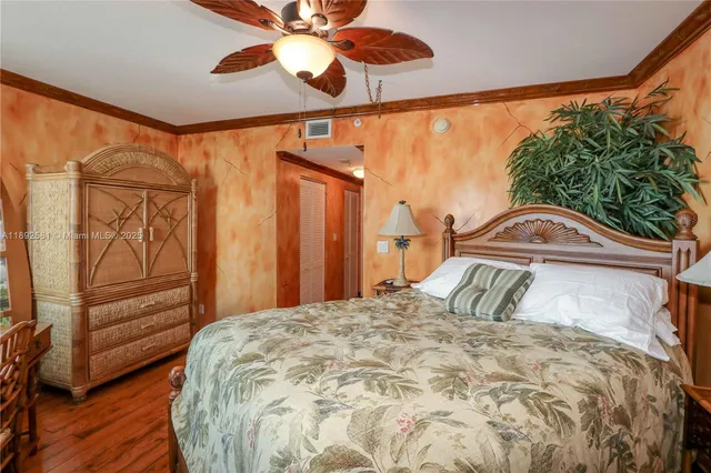 a view of a bedroom with wooden floor and door