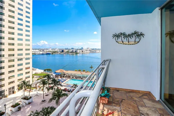 a living room with couches a flat screen tv and kitchen view
