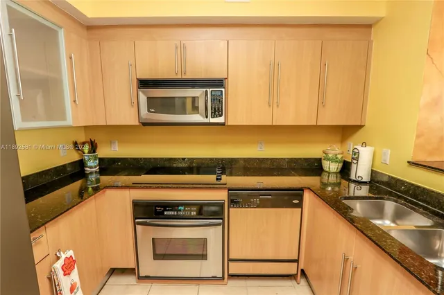 a kitchen with stainless steel appliances granite countertop a sink refrigerator and microwave