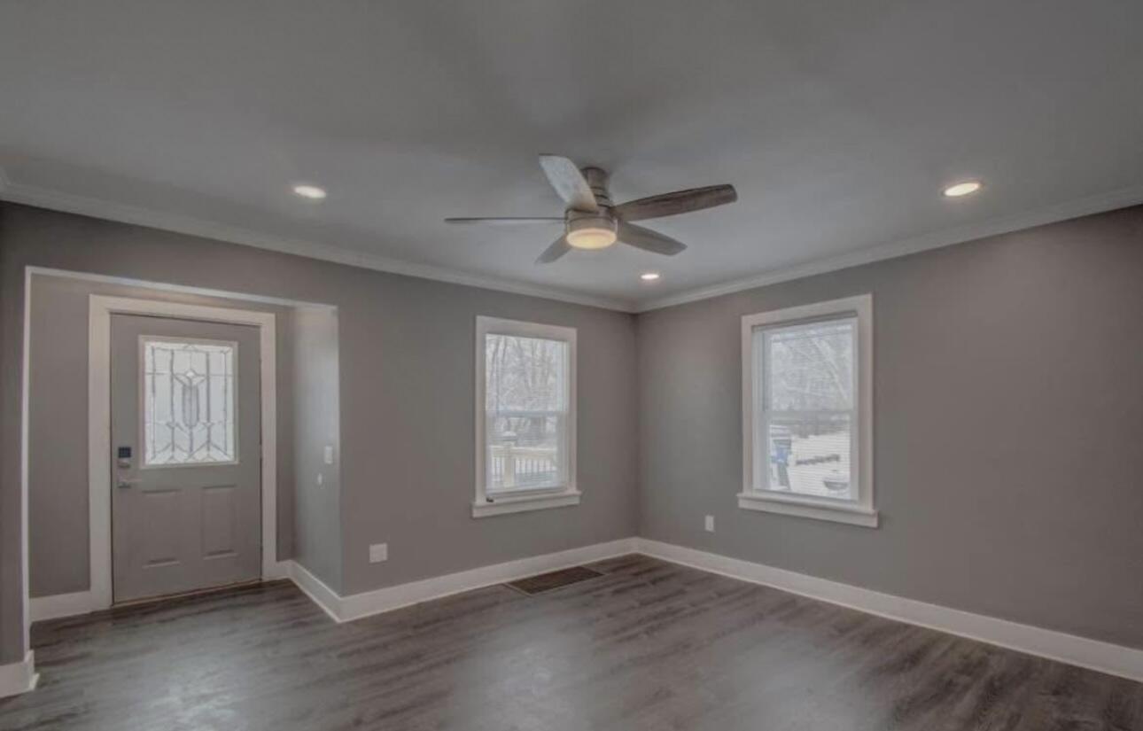 6568 Miller Avenue Gary, IN 46403 - Photo 2 of 11 an empty room with wooden floor ceiling fan and windows