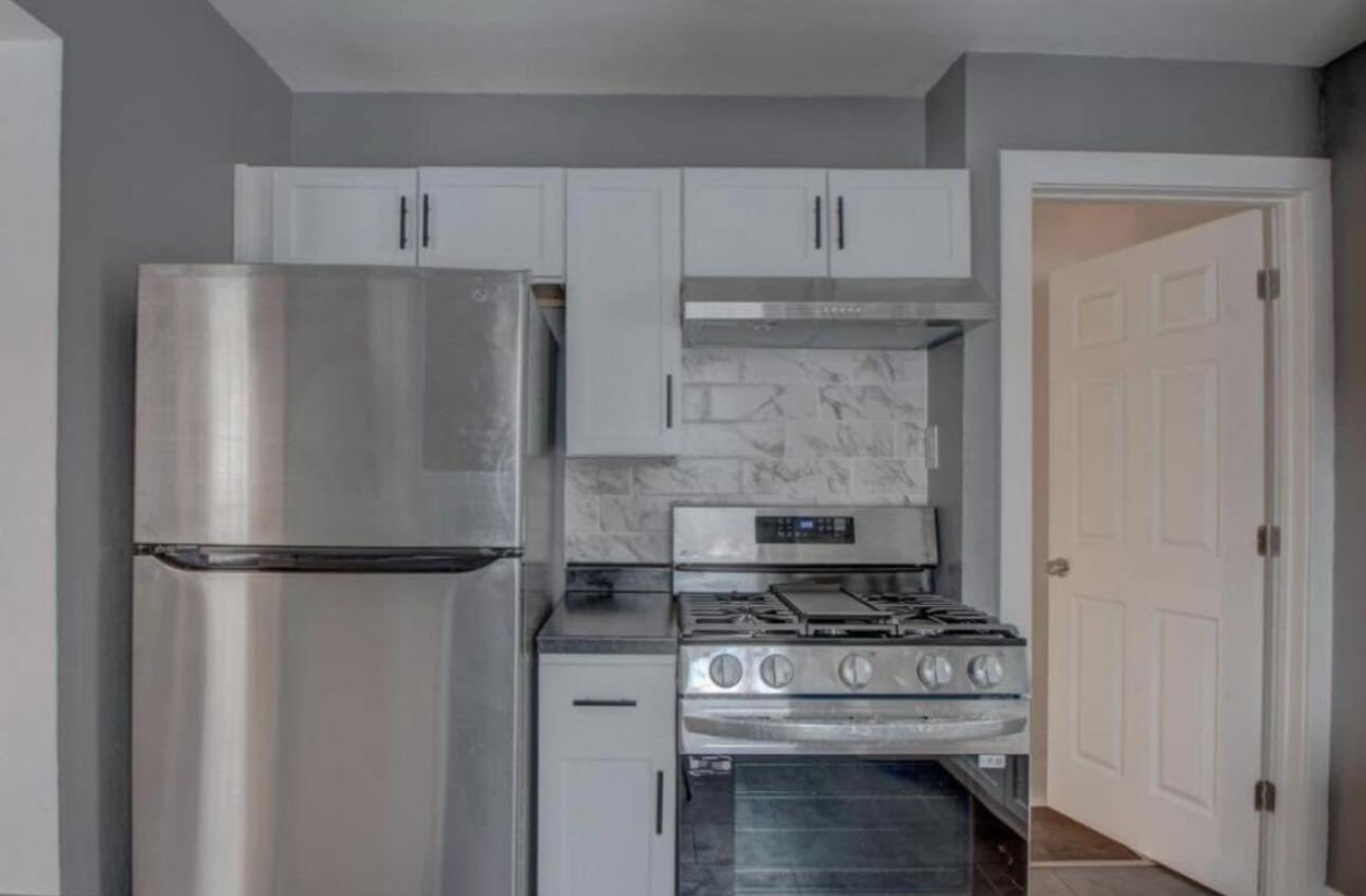 6568 Miller Avenue Gary, IN 46403 - Photo 5 of 11 a kitchen with a refrigerator and a stove top oven