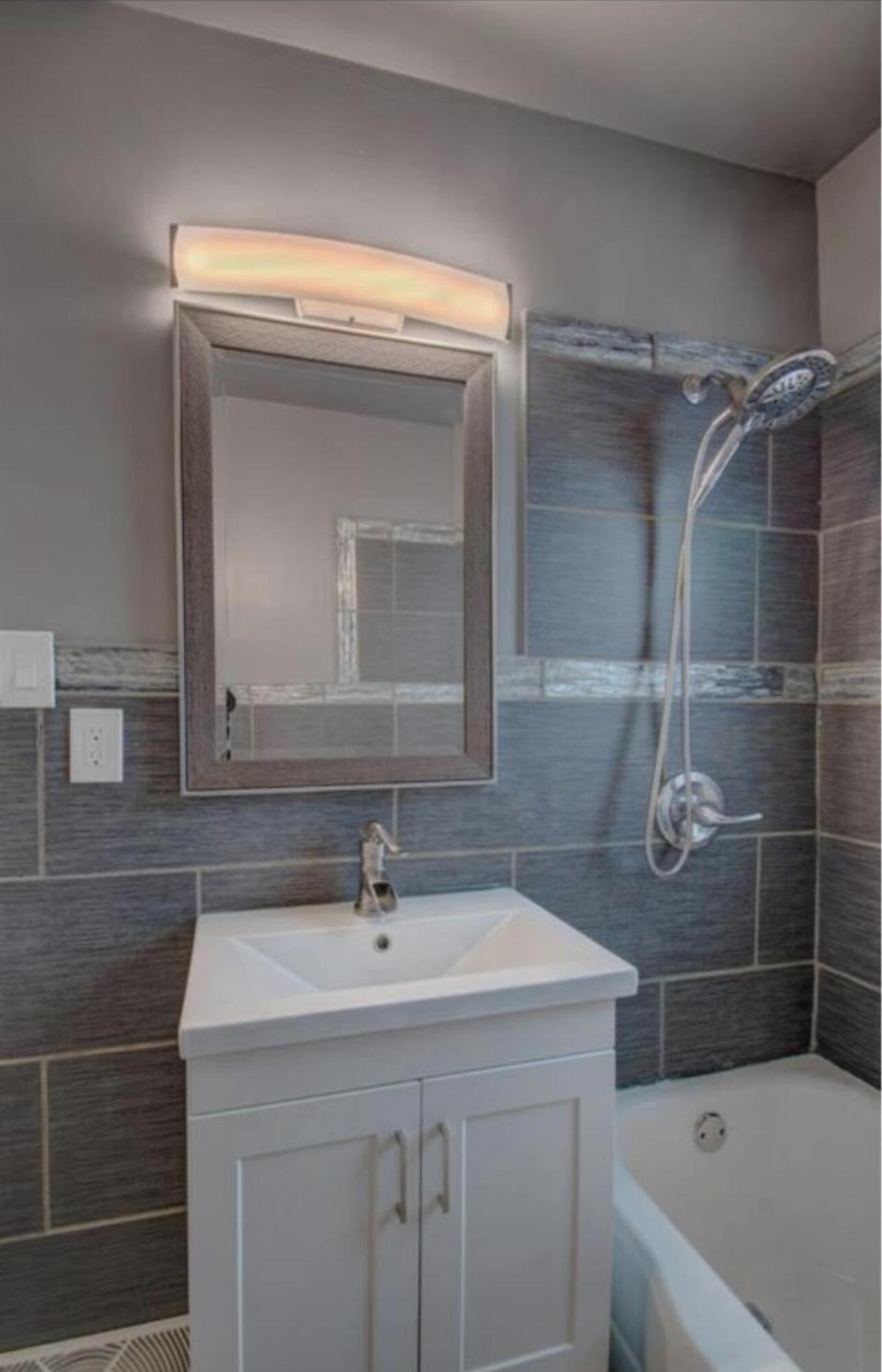 6568 Miller Avenue Gary, IN 46403 - Photo 9 of 11 a bathroom with a sink a vanity a mirror and a bathtub