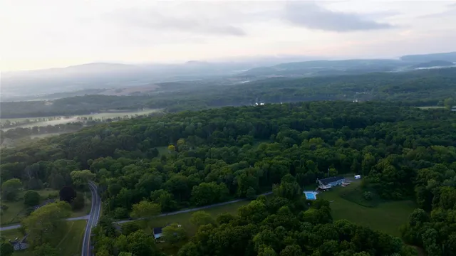 an aerial view of residential houses with outdoor space and trees