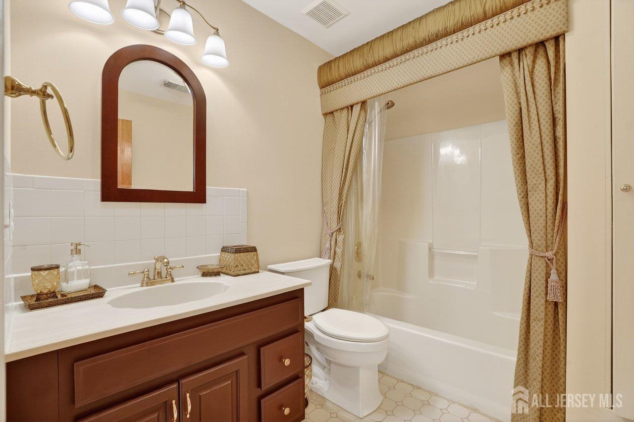 1 Wakefield Drive Edison, NJ 08820 - Photo 19 of 29 a bathroom with a sink a mirror a toilet and shower