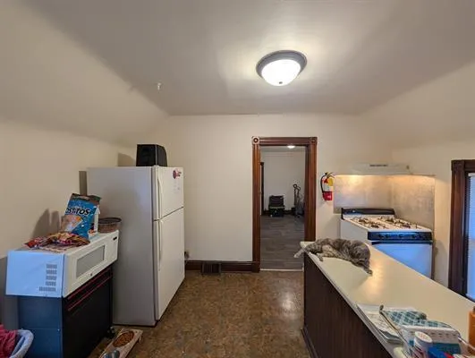 a kitchen with refrigerator and cabinets
