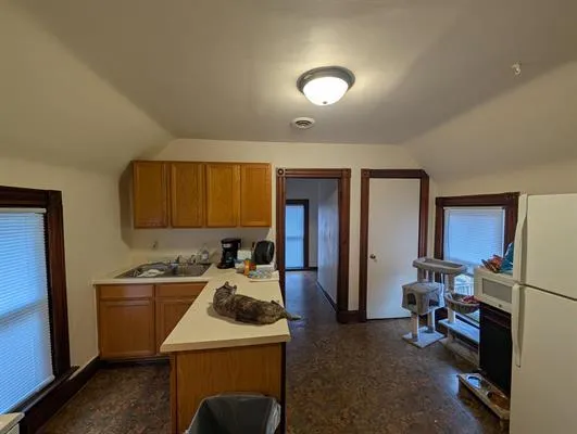 a view of a kitchen with a sink and a refrigerator