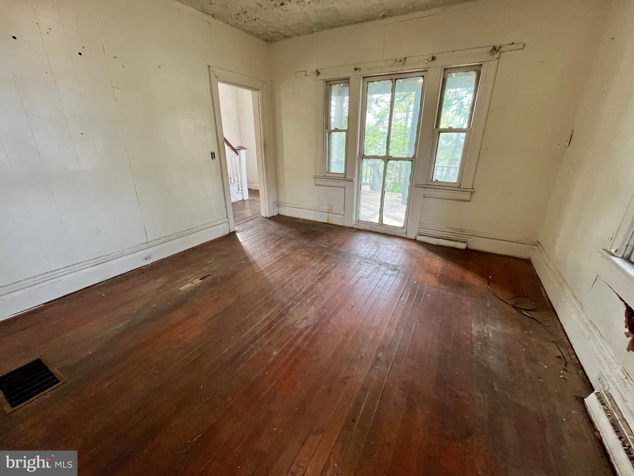 407 Carruthers Street Lexington, VA 24450 - Photo 5 of 29 an empty room with wooden floor and windows