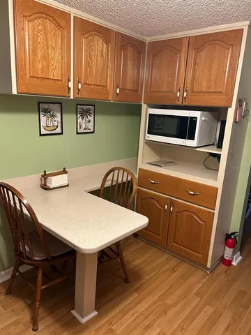 a kitchen with a wooden table chairs and microwave