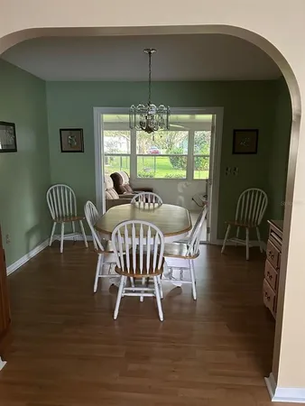 a dining room with furniture wooden floor and a chandelier
