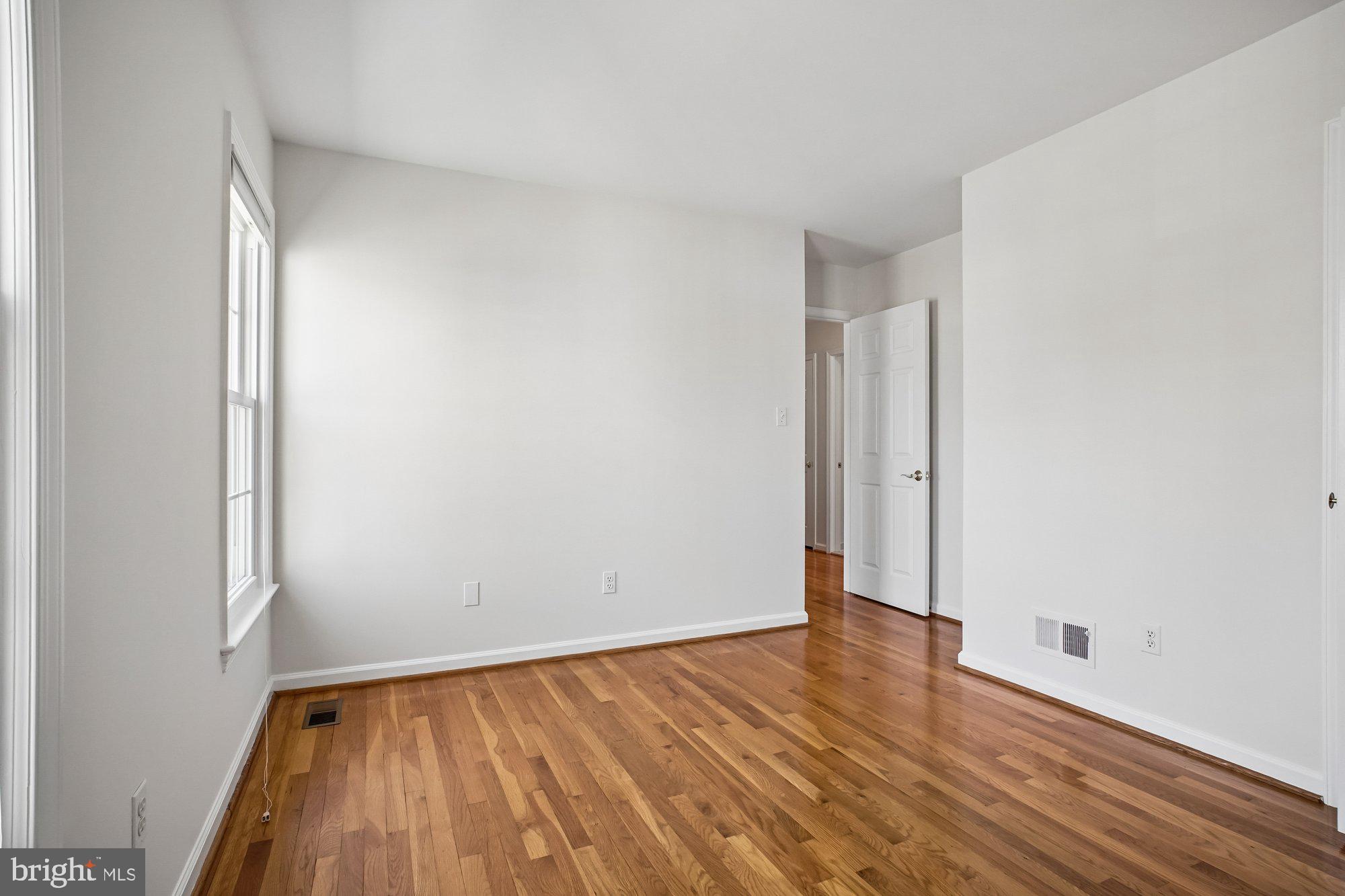 2126 Docket Lane Vienna, VA 22181 - Photo 35 of 63 a view of an empty room with wooden floor and a window