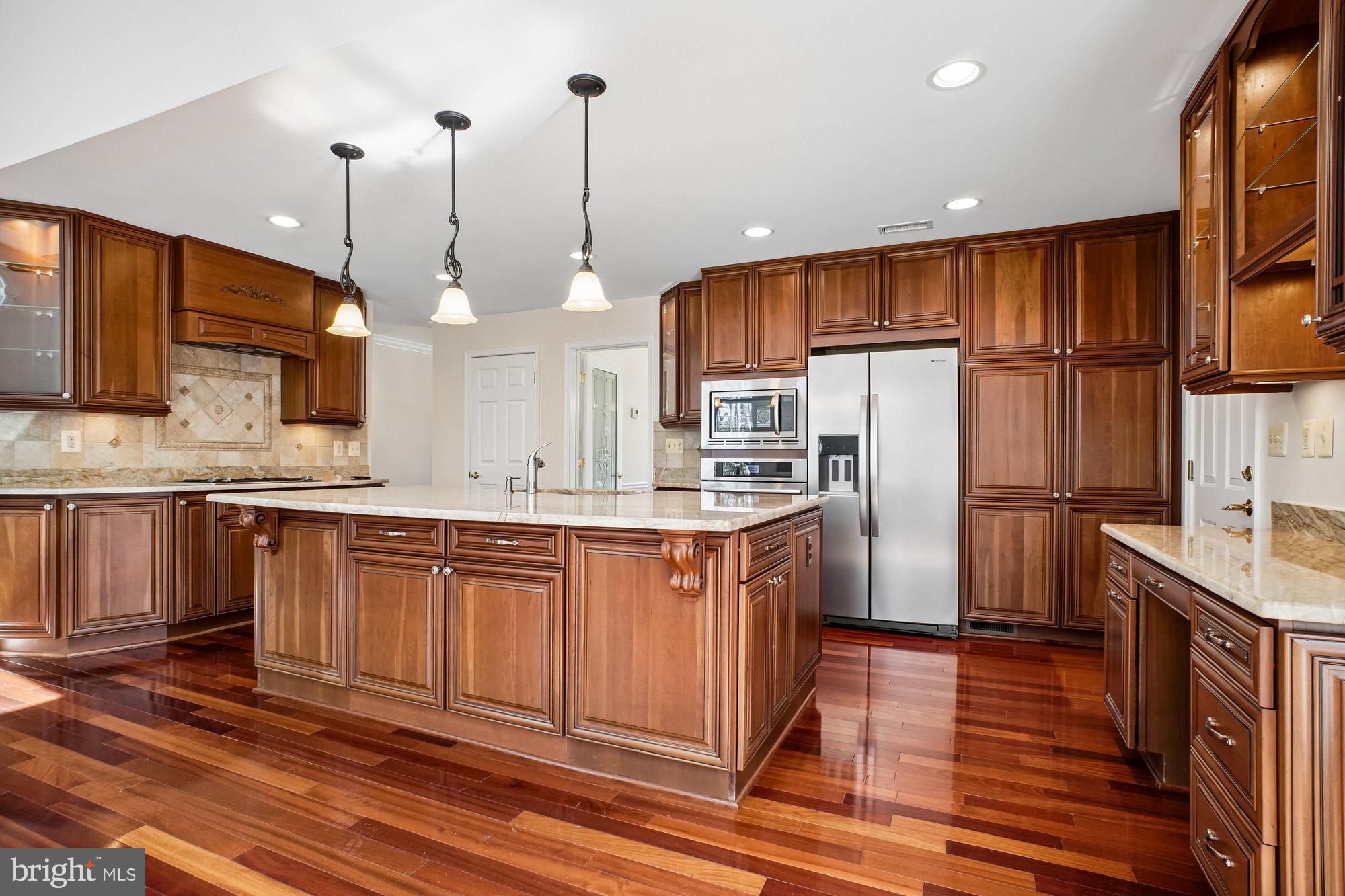 2126 Docket Lane Vienna, VA 22181 - Photo 10 of 63 a kitchen with stainless steel appliances granite countertop a refrigerator a sink dishwasher a kitchen island with wooden cabinets and floor