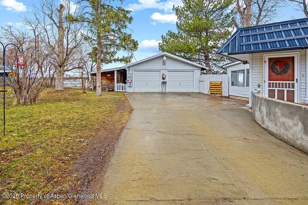 a view of a house with a yard and large tree