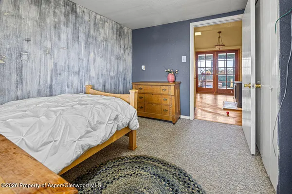 a view of a dining room with furniture and a painting on the wall