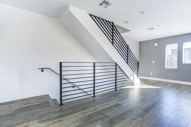 a view of a hallway with wooden floor and stairs