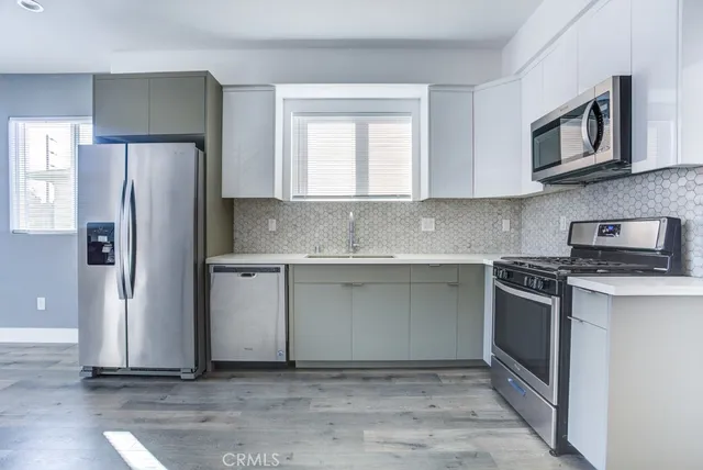 a kitchen with cabinets appliances and a window