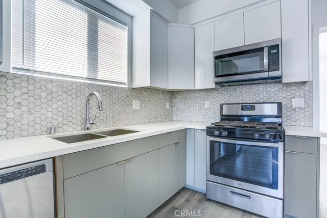 a kitchen with stainless steel appliances granite countertop a sink a stove and microwave