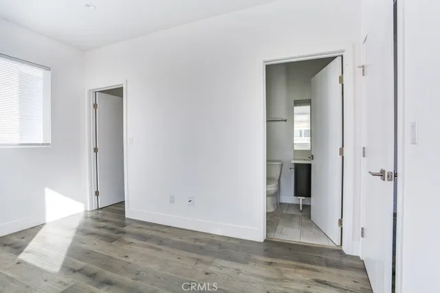 a view of a hallway with wooden floor and closet area