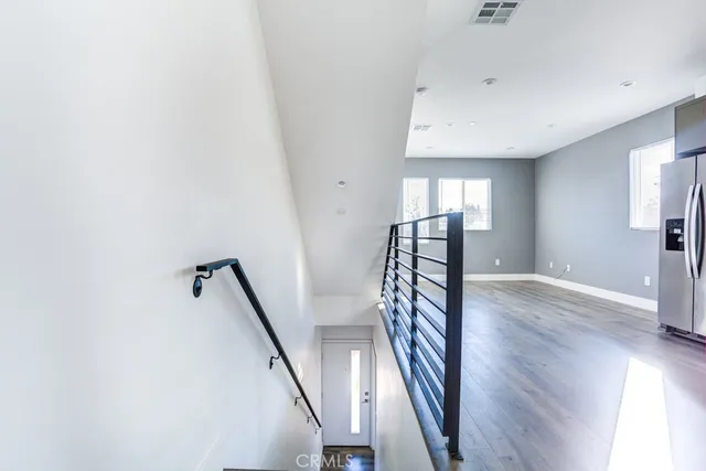a view of a hallway with wooden floor and staircase