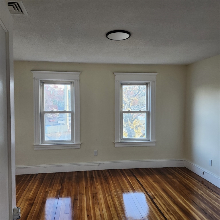468 Springfield Street Agawam, MA 01001 - Photo 12 of 19 an empty room with wooden floor and windows