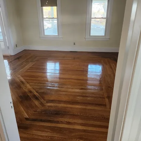 a view of wooden floor and windows in a room