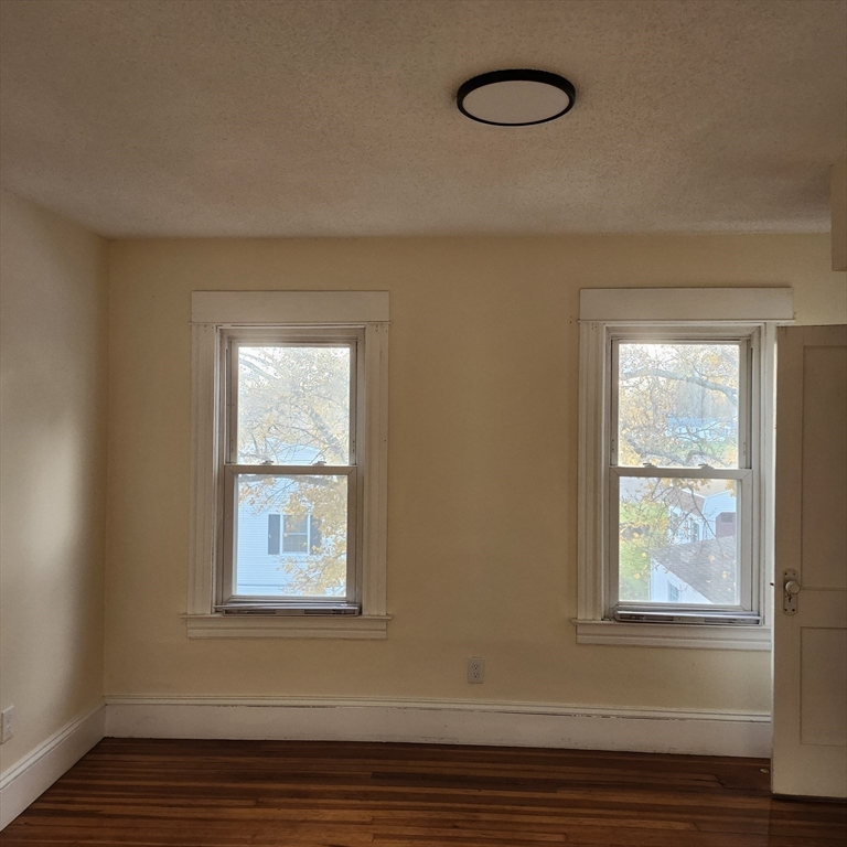 468 Springfield Street Agawam, MA 01001 - Photo 9 of 19 an empty room with wooden floor and windows