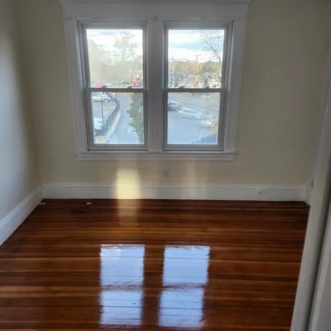 a view of a room with wooden floor and window
