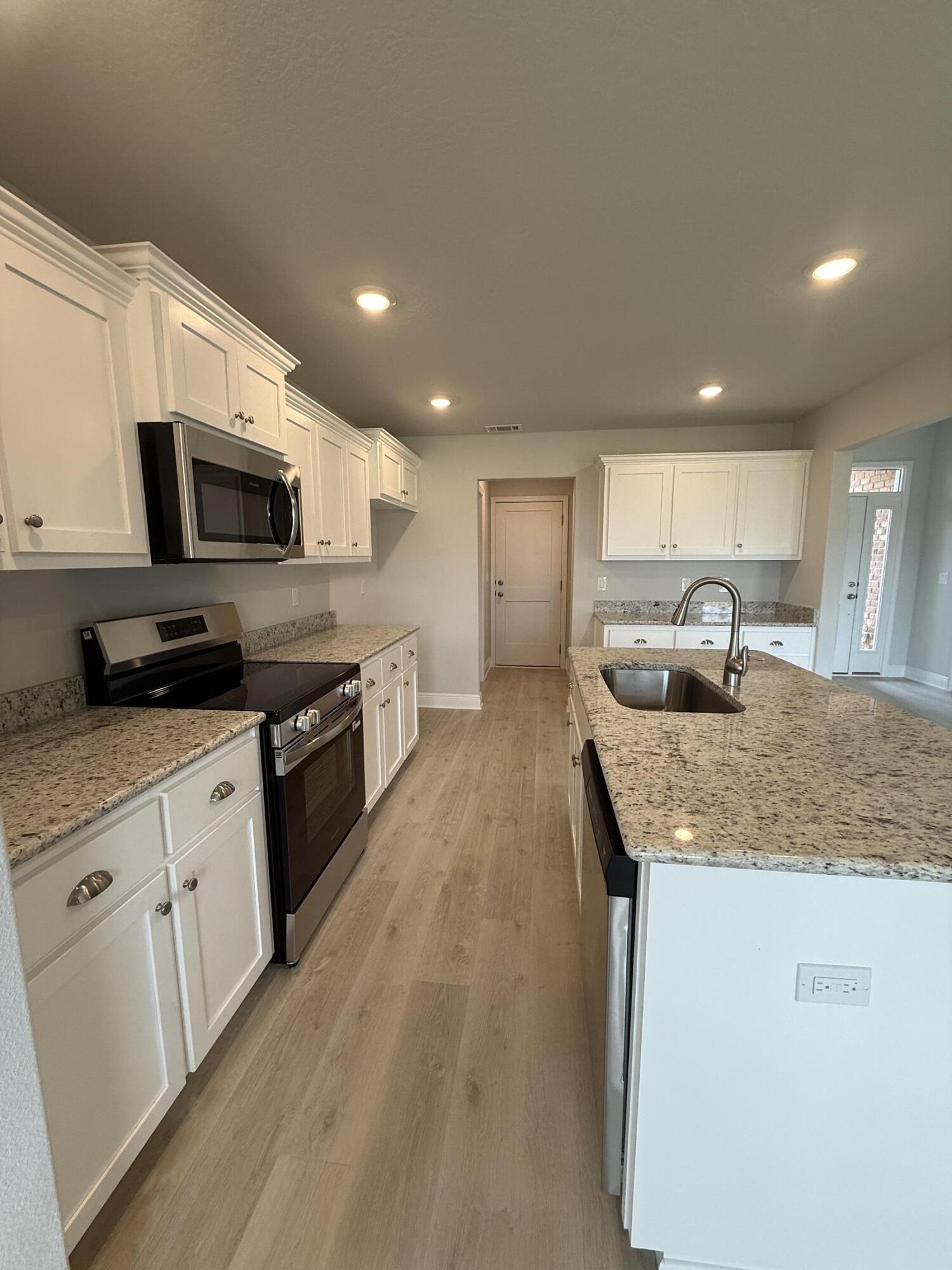 6002 Crocket Cove Crestview, FL 32539 - Photo 27 of 29 a kitchen with stainless steel appliances granite countertop a sink a stove top oven a counter space and cabinets