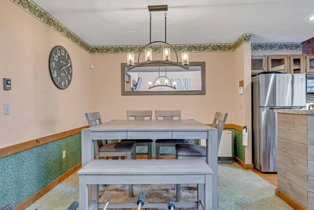 a view of a dining room with furniture a chandelier and wooden floor