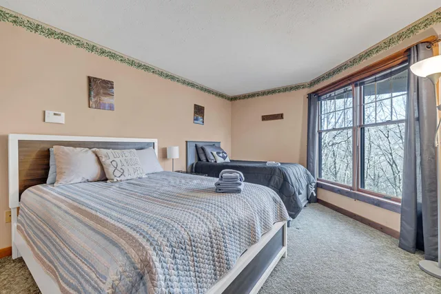 a bedroom with bed and a large window